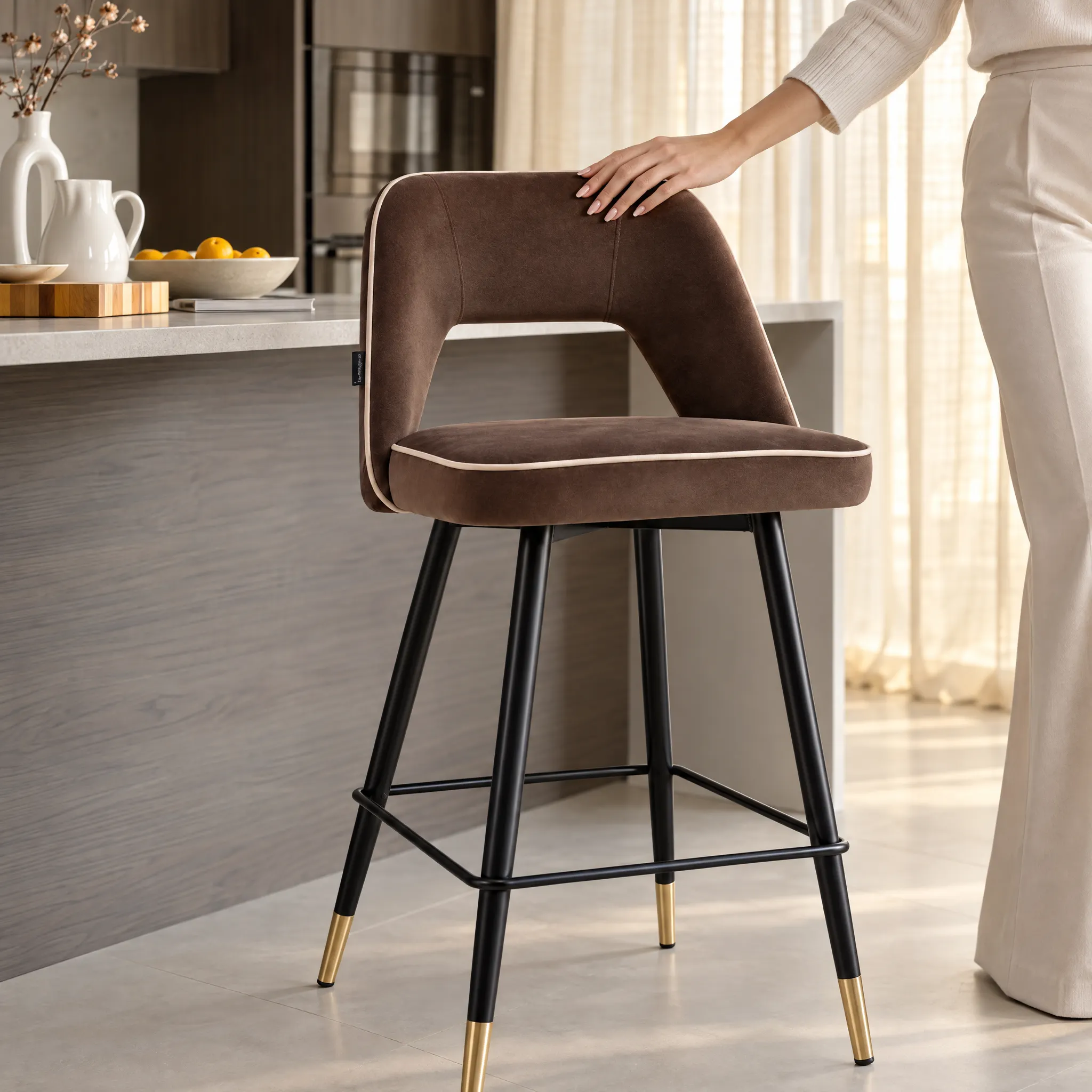 Generated with Kive.ai - Upholstered bar stool Create a close environmental lifestyle photograph centered on this exact bar stool. Show a well-groomed feminine hand gently gliding over the brown upholstered ba.png